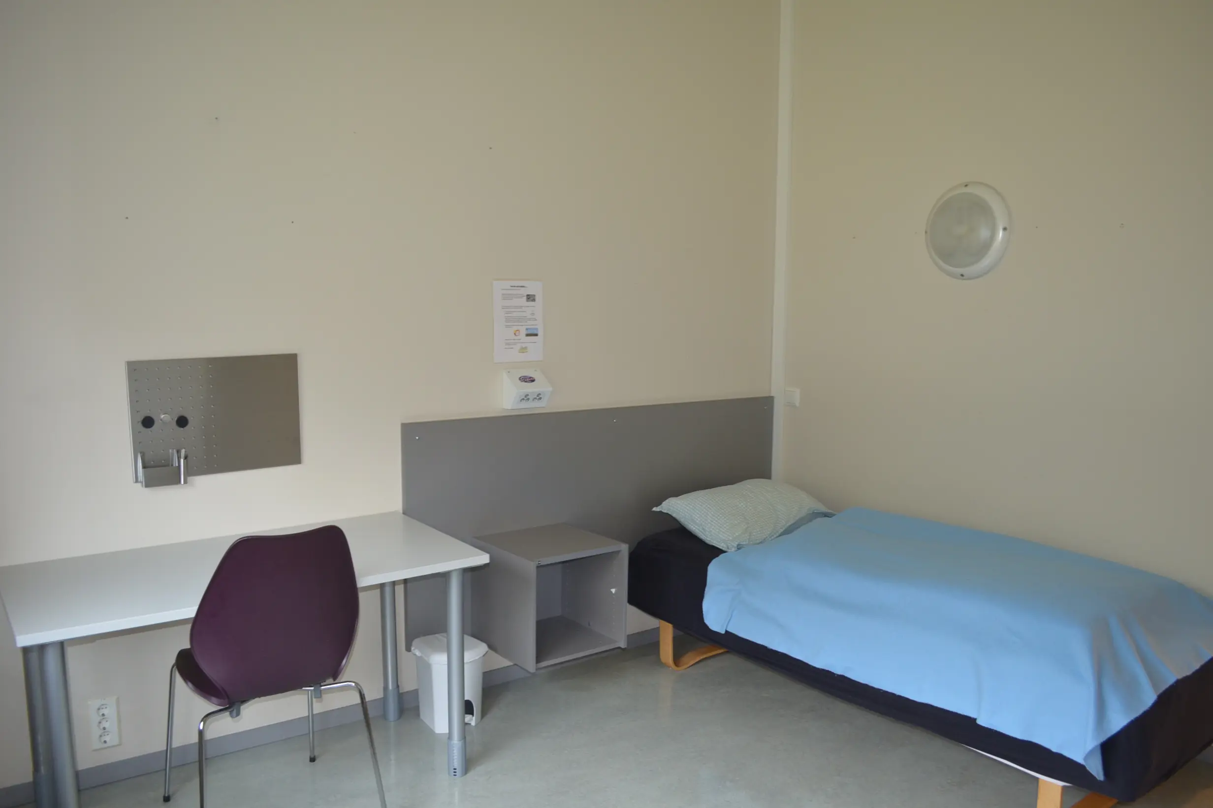 Et rom med seng og skrivebord