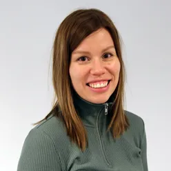 En kvinne som smiler til kameraet