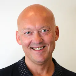 En skallet mann smiler